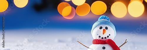 Christmas winter background with snowman in snow and blurred bokeh background.Merry Christmas and happy new year greeting card with copy space. © Kseniya Ananko