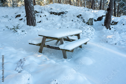 Resting area with benches and table covered in snow