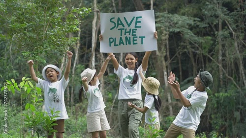 Asian teachers and children holding a sign with the message 