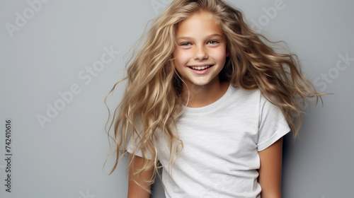 Smiling teenage girl in white t-shirt on a gray background mockup. Scandinavian girl model. Childhood lifestyle concept. Mockup copy space
