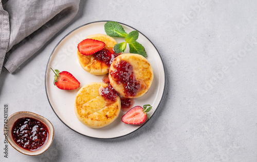 Wallpaper Mural Cottage cheese, cheesecakes or syrniki  sprinkled berry sauce on a white plate  with strawberry on a light background with jam and napkin. Torontodigital.ca