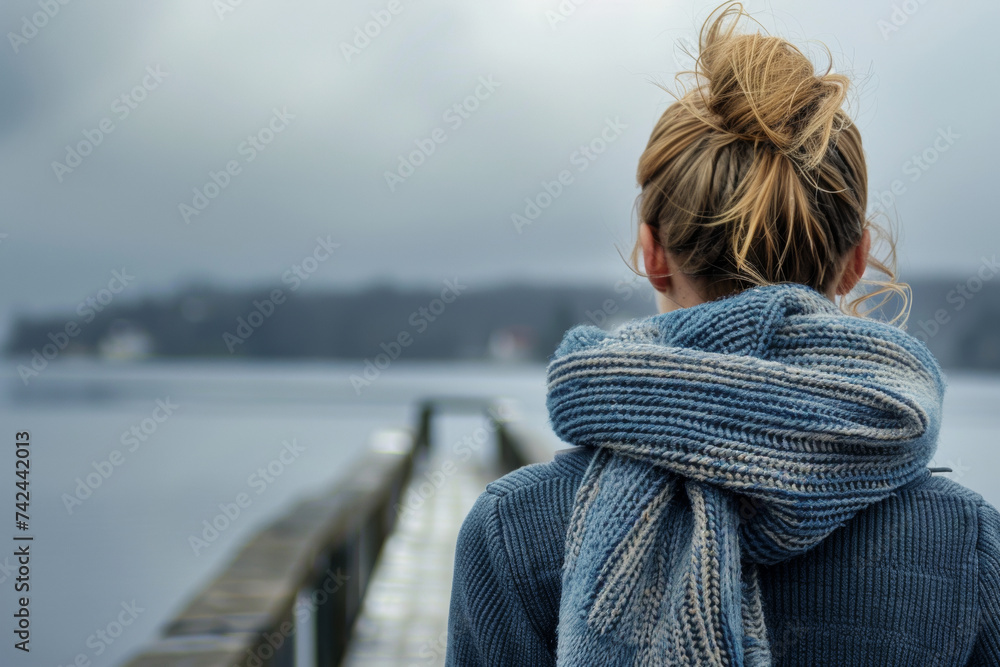 Woman in Large Scarf Contemplating the Vast Sea from a Pier Woman in Large Scarf Contemplating the Vast Sea from a Pier
