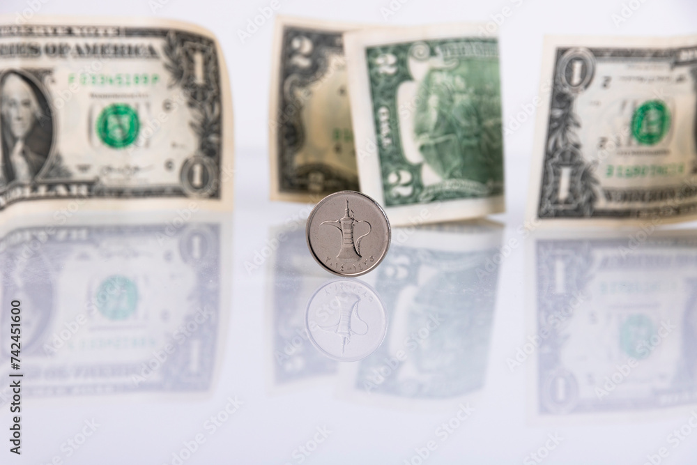 UAE currency dirham coin, on the background of paper American dollars. Copy space. UAE currency dirham coin, on the background of paper American dollars. Copy space.