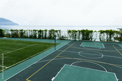 Outdoor Volleyball court with a net in the morning next to the sea. © Iryna