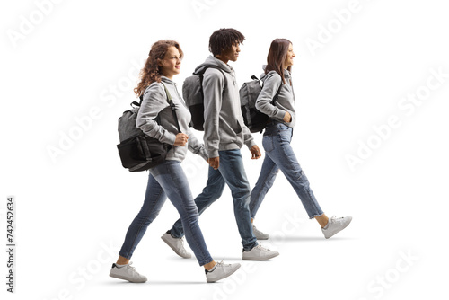 Full length profile shot of an african american male student and caucasian female students walking