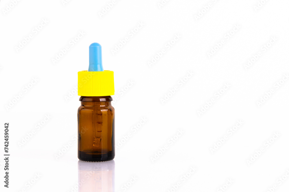 Glass bottle of brown color for medicine with a pipette, on a white background. Copy space.