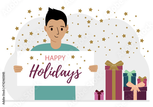 A man is holding a large poster with the text Happy Holidays. Lots of gift boxes.