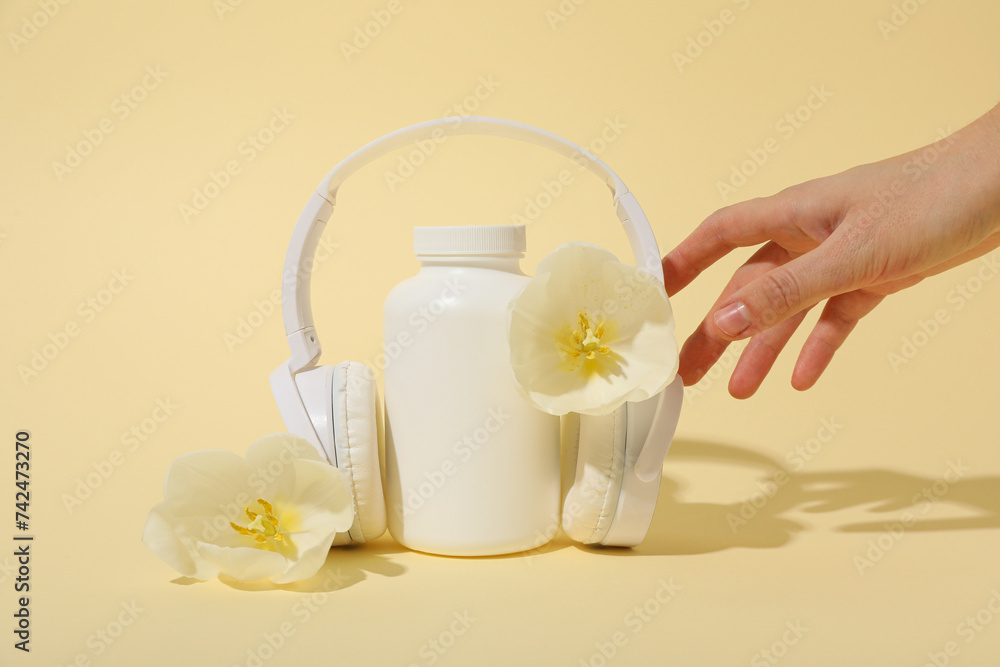 A bottle with bio-additives, with flowers, on a light background. A bottle with bio-additives, with flowers, on a light background.