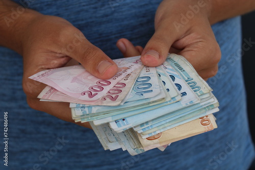 man counting Turkish money with his hand. Turkish lira banknotes. The paper currency of Turkey. Current Turkish liras are issued by The Central Bank of the Republic of Turkey.  photo