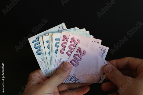 Fototapeta Naklejka Na Ścianę i Meble -  man counting Turkish money with his hand. Turkish lira banknotes. The paper currency of Turkey. Current Turkish liras are issued by The Central Bank of the Republic of Turkey. 