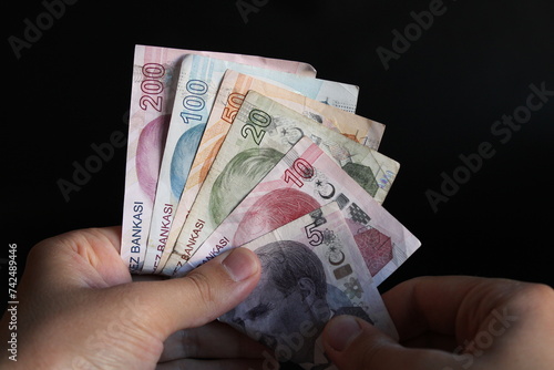 Fototapeta Naklejka Na Ścianę i Meble -  man counting Turkish money with his hand. Turkish lira banknotes. The paper currency of Turkey. Current Turkish liras are issued by The Central Bank of the Republic of Turkey. 