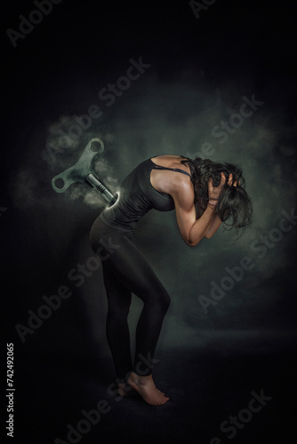 Conceptual Woman with a key in her back like a wind up doll to represent the oppression of women photo
