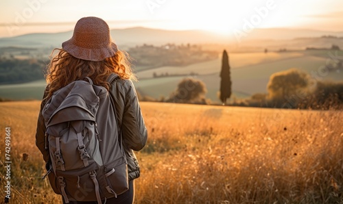 Tuscan Serenity: Against the Backdrop of a Tuscan Sunset, a Woman Tourist Walking at the Lush Fields, Captivated by Tuscany's Timeless Splendor.   © Mr. Bolota