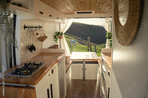 Interior of a cozy camper with Nordic design in a bucolic landscape surrounded by cows at sunset.
Lifestyle, travel, tourism, outdoors