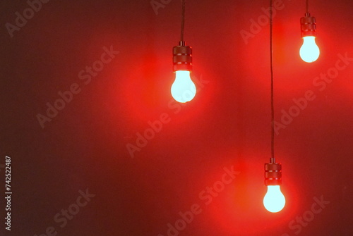 Drei Glühbirnen vor knallroter Wand photo