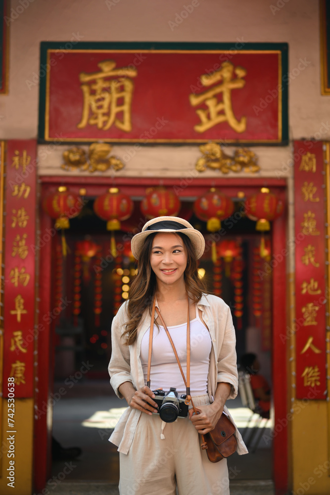 Portrait of beautiful female traveller standing at a Chinese Temple locating in the downtown