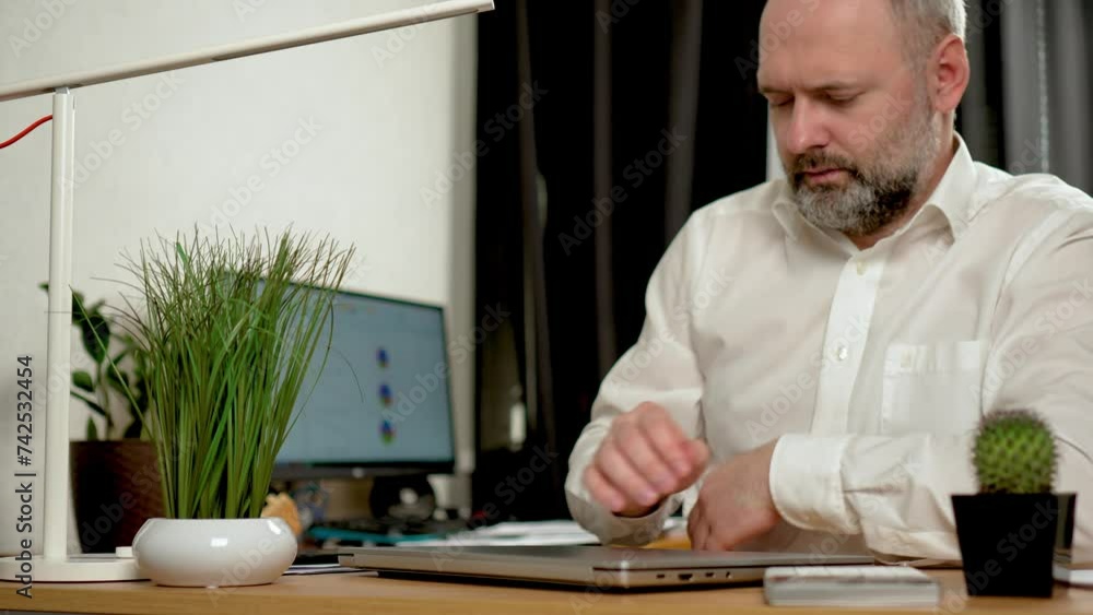 Creative entrepreneur open laptop, typing on keyboard, browsing internet and searching customer emails on office technology. Mature age, middle age, mid adult man working at home office desk