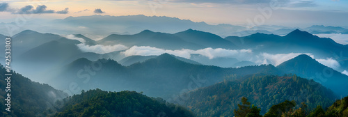 Amazing wild nature view of layer of mountain forest landscape with cloudy sky. Natural green scenery of cloud and mountain slopes background. Maehongson Thailand. Panorama view.