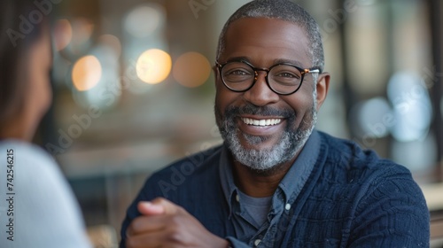 A middle-aged businessman smiles as he shakes hands with his partner