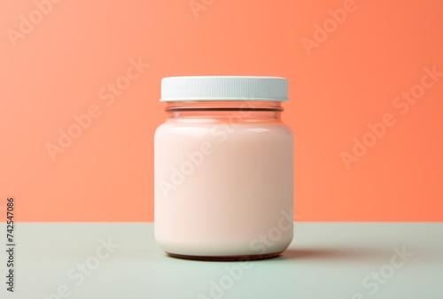 a jar of cream sitting on a pink background