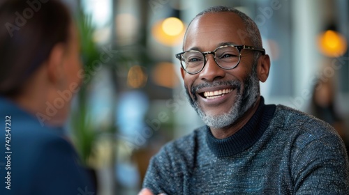 A middle-aged businessman smiles as he shakes hands with his partner