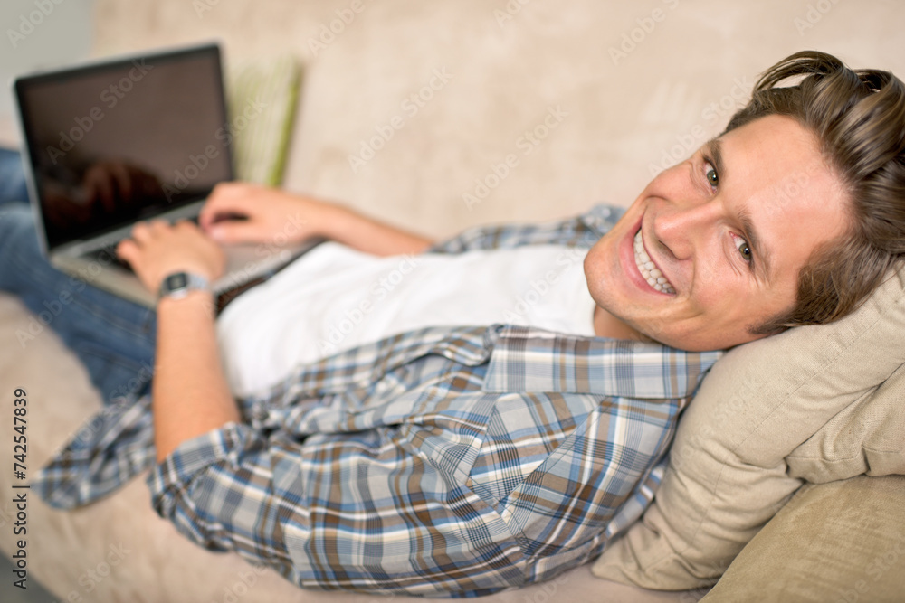 Man, portrait and laptop on sofa or relax for online browsing at home or streaming movie, internet or scrolling. Male person, face and couch at house in London for weekend, resting or entertainment Man, portrait and laptop on sofa or relax for online browsing at home or streaming movie, internet or scrolling. Male person, face and couch at house in London for weekend, resting or entertainment