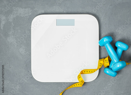 tailor measuring tape, weights and scales on a gray concrete background, top view photo