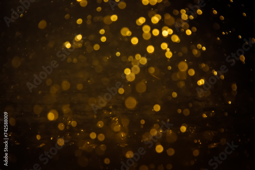 Blurred photo with golden dots visible glittering  shining brightly look and feel luxurious Suitable for use as a wallpaper