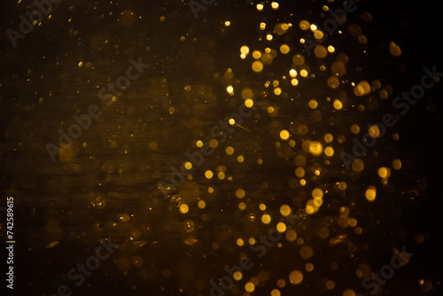 Blurred photo with golden dots visible glittering, shining brightly look and feel luxurious Suitable for use as a wallpaper