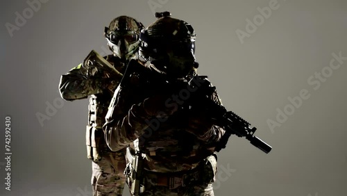 two professional soldiers with guns in studio, warriors in modern military equipment, war conflict photo
