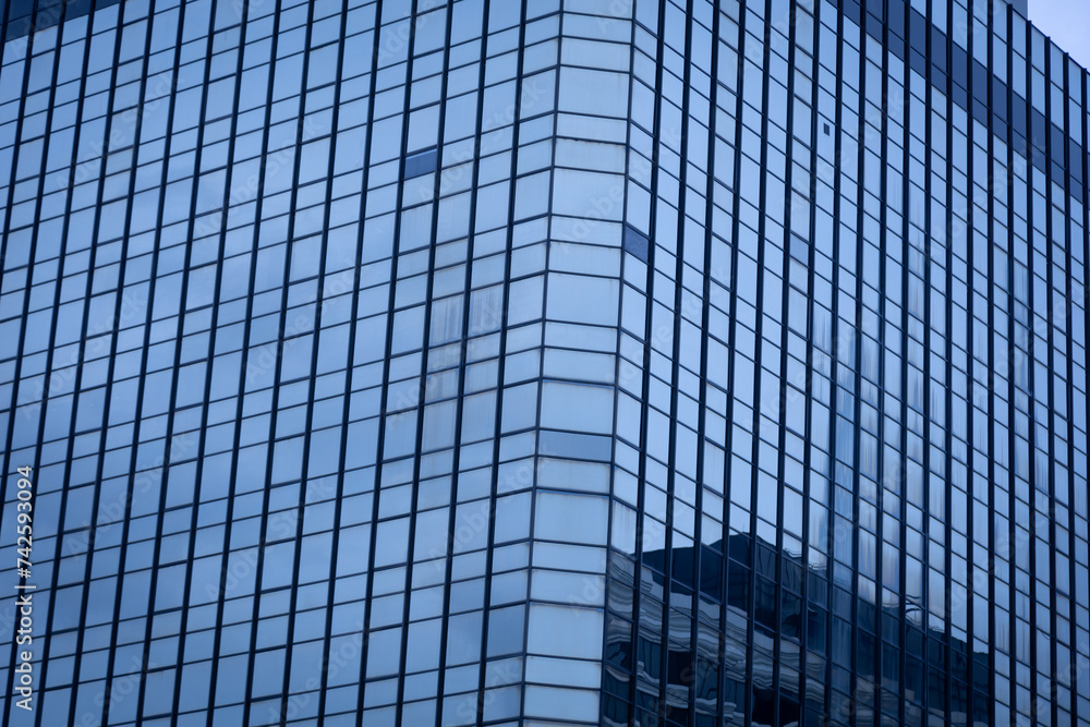 The modern building in the business district has glass windows to let in the light. The modern building in the business district has glass windows to let in the light.