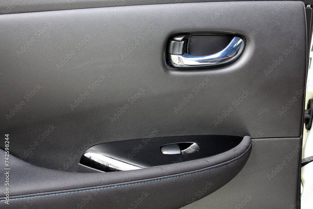 Electric Car door trim with windows control. Car Inside Door Handle Interior. Leather Door trim. Front door trim of a Electric car. Electric Car interior.