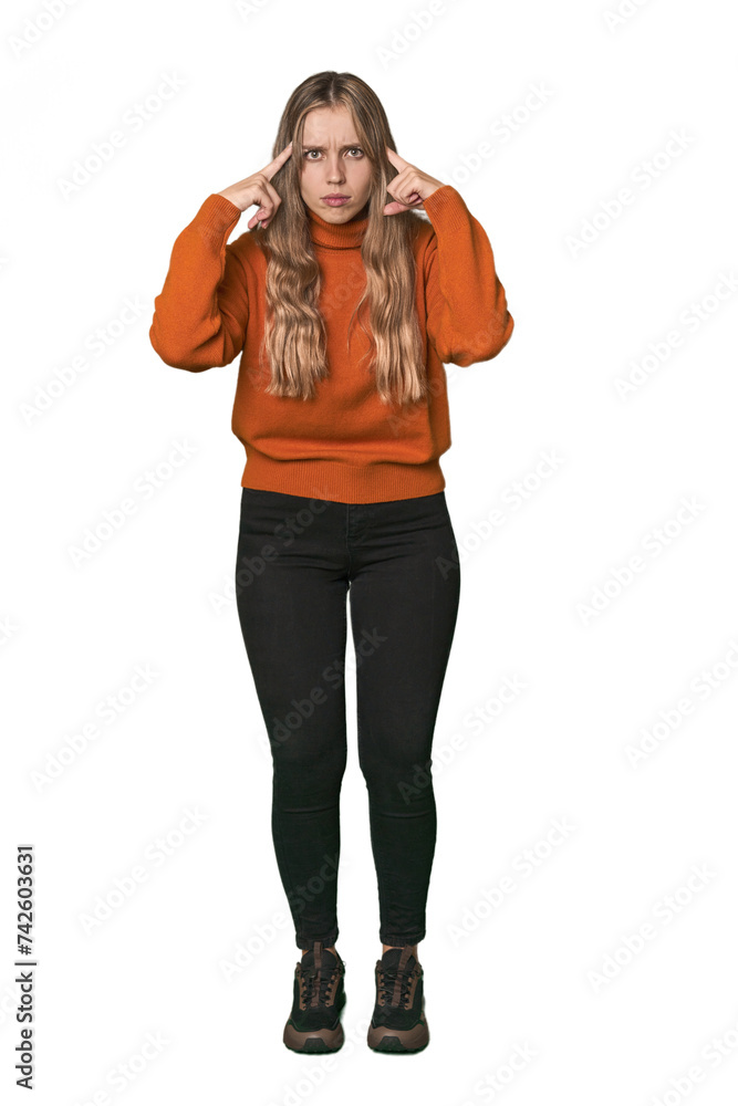 Studio portrait of a blonde Caucasian woman focused on a task, keeping forefingers pointing head. Studio portrait of a blonde Caucasian woman focused on a task, keeping forefingers pointing head.