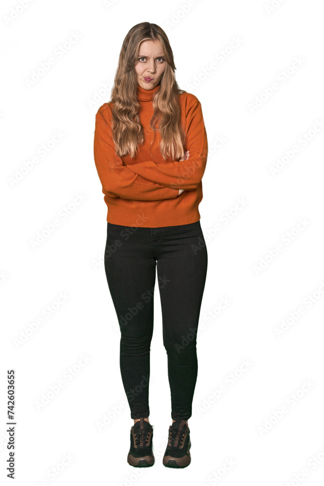 Studio portrait of a blonde Caucasian woman frowning face in displeasure, keeps arms folded. Studio portrait of a blonde Caucasian woman frowning face in displeasure, keeps arms folded.