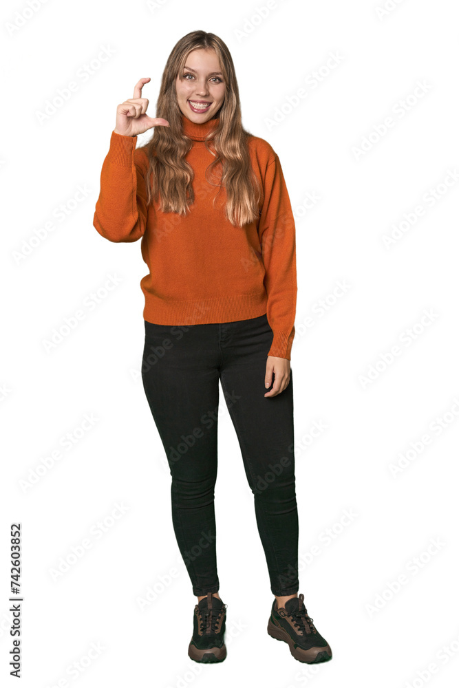Studio portrait of a blonde Caucasian woman holding something little with forefingers, smiling and confident. Studio portrait of a blonde Caucasian woman holding something little with forefingers, smiling and confident.