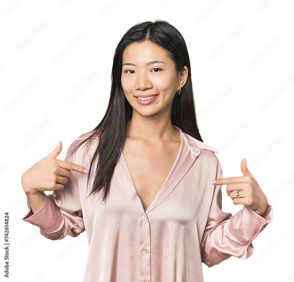 Young Chinese woman in studio setting surprised pointing with finger, smiling broadly. Young Chinese woman in studio setting surprised pointing with finger, smiling broadly.
