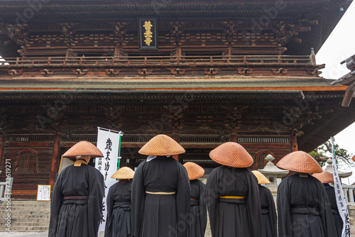 Nagano, Japan. Japanese Zen Buddhist monks of the Soto school with Kasa hats looking at the Sanmon Gate in Zenko-ji, a buddhist temple photo