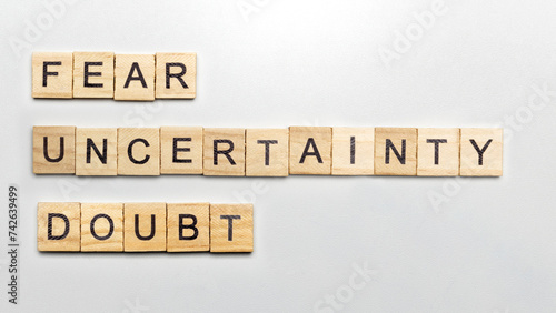 The row of wooden cubes with 'Fear Uncertainty Doubt' text