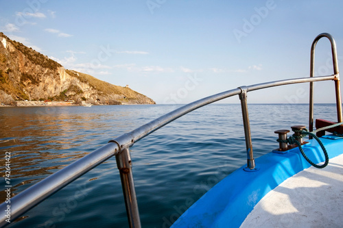Motorboat sailing along the coast. Cruising alongshore to sightsee the cliffs photo