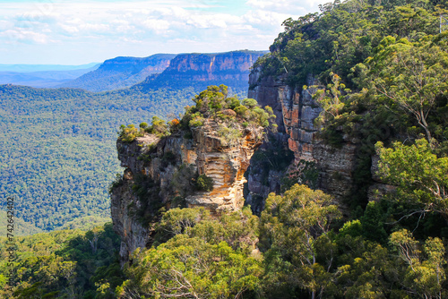 Orphan Rock, a rocky outcrop protruding over the rainforest of the Jamison Valley in Scenic World, a famous tourist attraction of the Blue Mountains National Park, New South Wales, Australia photo