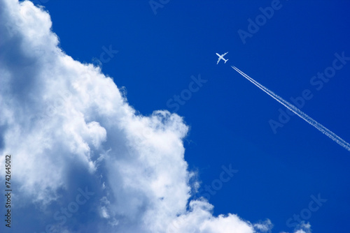 Cuadro en lienzo a passenger plane with vapour trails high in the blue sky