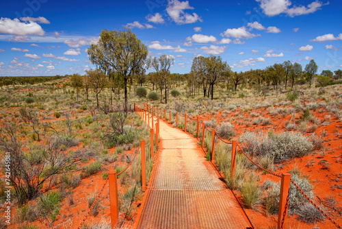 Catwalk leading to the Kata Tjuta dunes viewing area near Mount Olga, a large domed rock formation in Northern Territory, Central Australia, surrounded by bushland and steppes photo