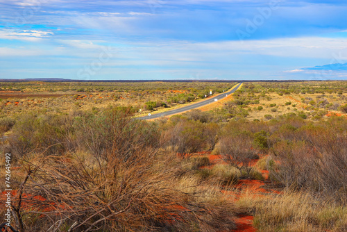 Long A4 road heading west in the the bushy terrain of the Red Center of the Northern Territory of Australia photo