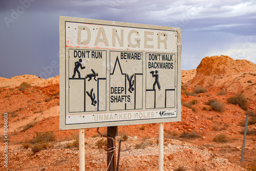 Danger sign outside Tom's Working Opal Mine in Coober Pedy, South Australia - Warning of deep mine shafts in the Australian desert