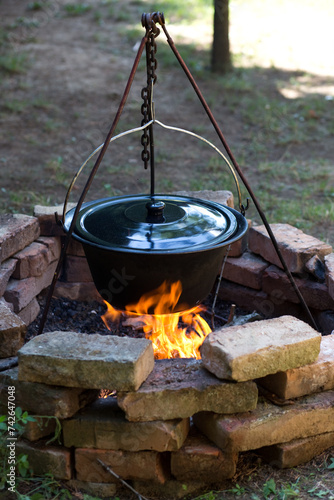 Outdoor cooking on fire in cauldron