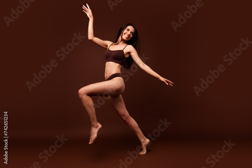 No retouch full body photo of graceful woman wear lingerie look at offer empty space running isolated on dark brown color background
