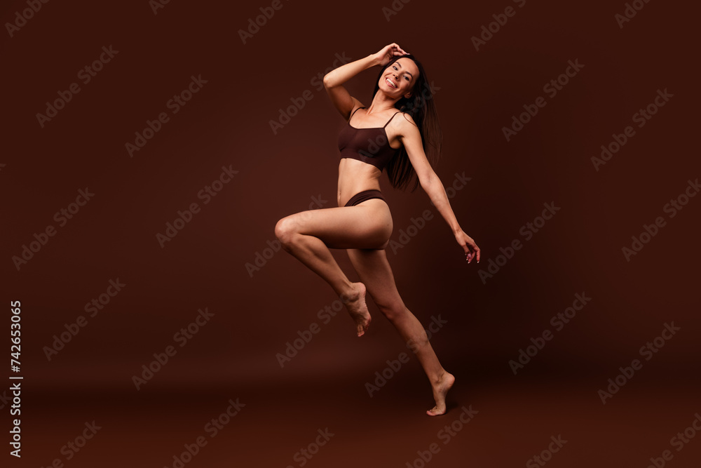 No retouch full body photo of self confident woman wear lingerie run empty space arm on hair isolated on dark brown color background