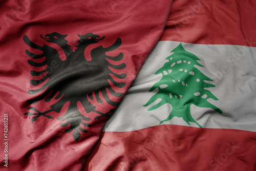 big waving national colorful flag of lebanon and national flag of albania . photo