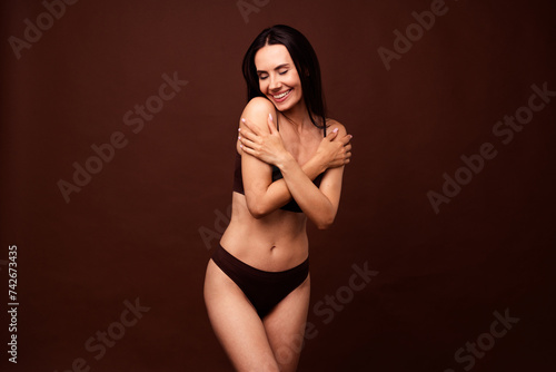 No retouch photo of gorgeous adorable woman wear lingerie with brunette hair cuddle her shoulders isolated on dark brown color background © deagreez