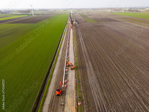 Laying of a pipe providing carbon dioxide gas to greenhouses. This captured and recycled gas was originally produced by industrial processes now resulting in reducing global emissions